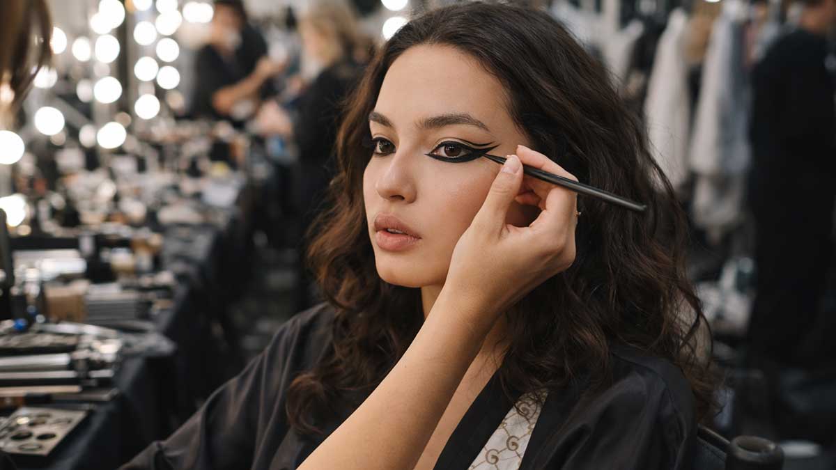 Beca Michie getting makeup done backstage at a fashion show