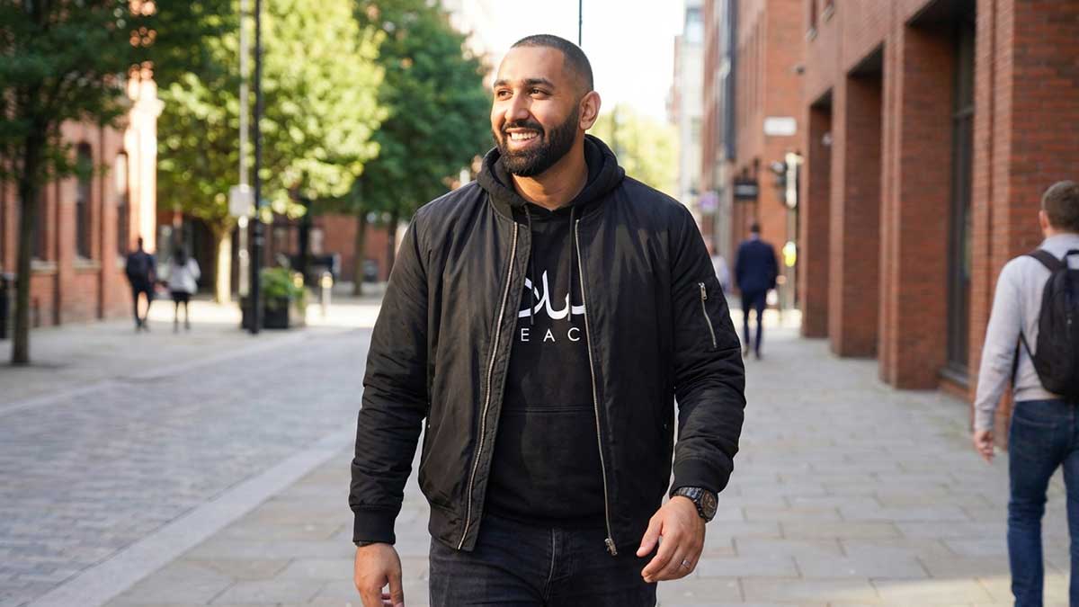 A candid lifestyle photo of Mouhammad Elbannan smiling in casual streetwear